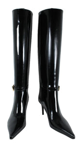 Black patent leather knee-high boots on a white background